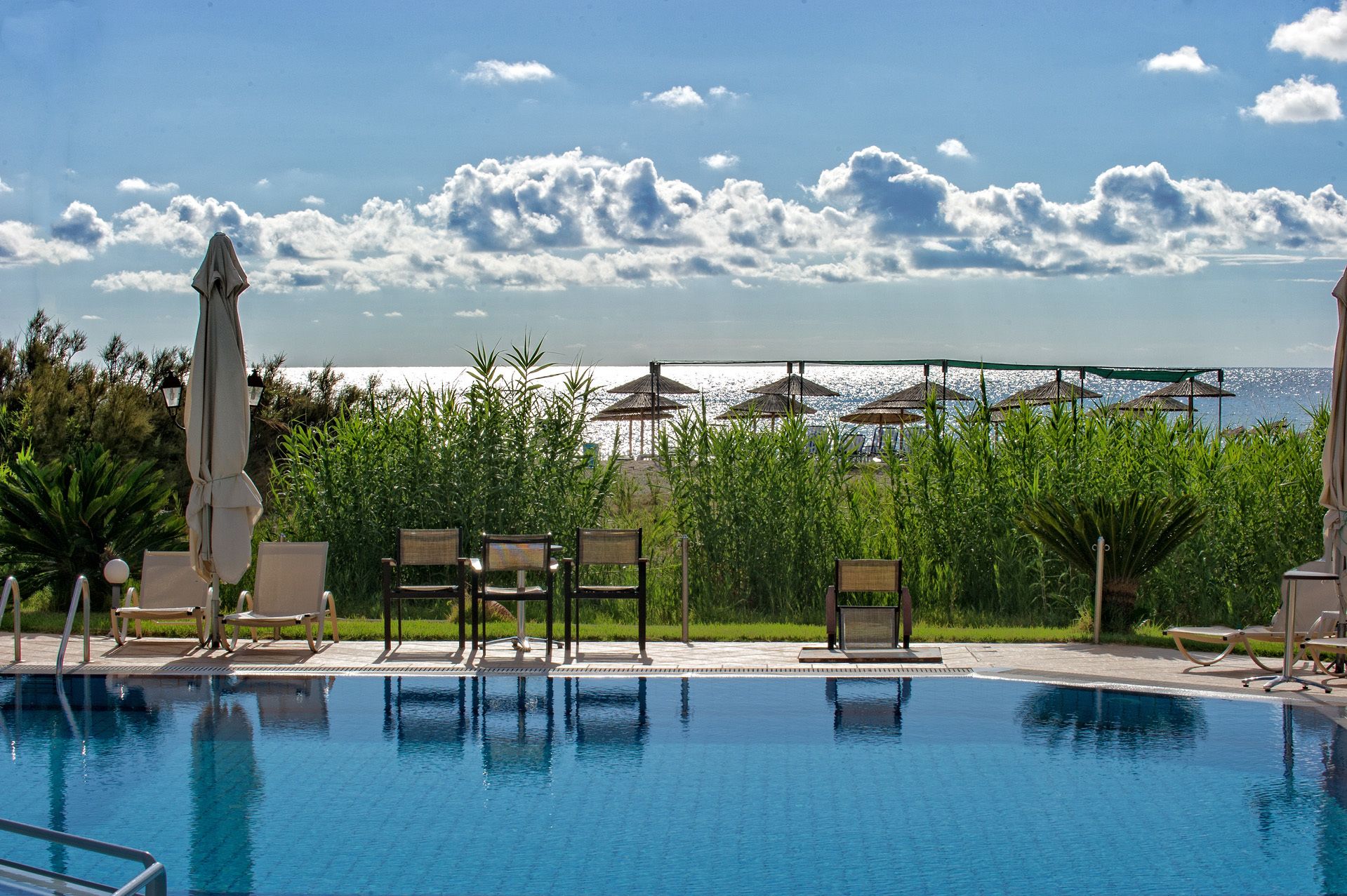 Een buitenzwembad, parasols voor strand/zwembad
