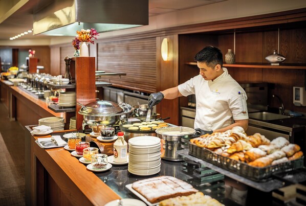 A buffet setup with various food items and a chef serving. - Harmony Hotel (Spindleruv Mlyn)