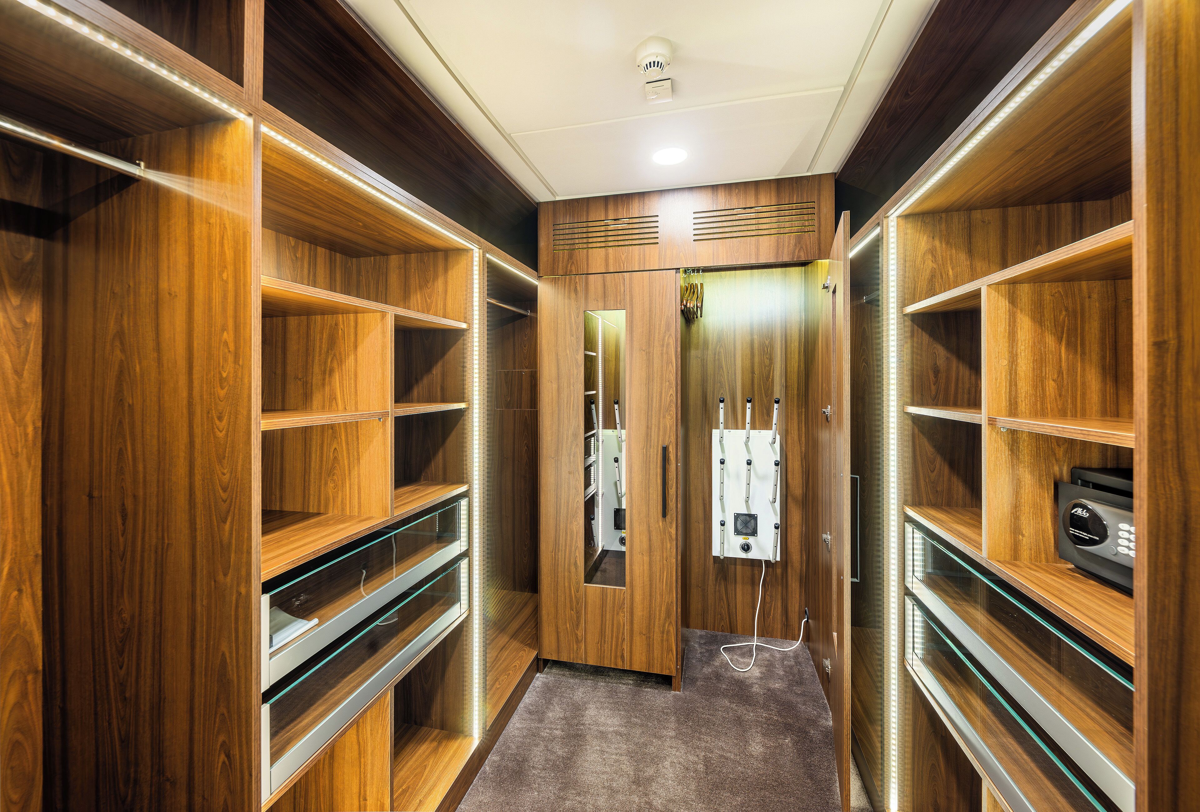 Un closet amplio con estantes de madera, un espejo y un calentador incorporado.