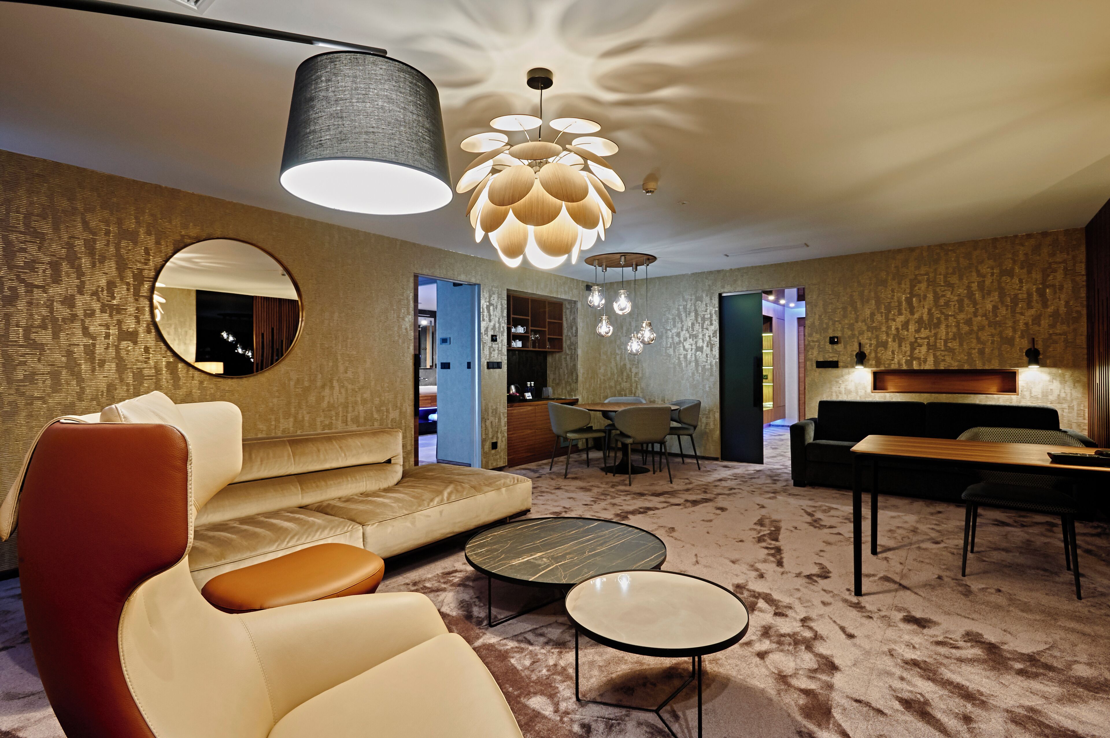 A modern living room with a sofa, round coffee table, and pendant lighting.