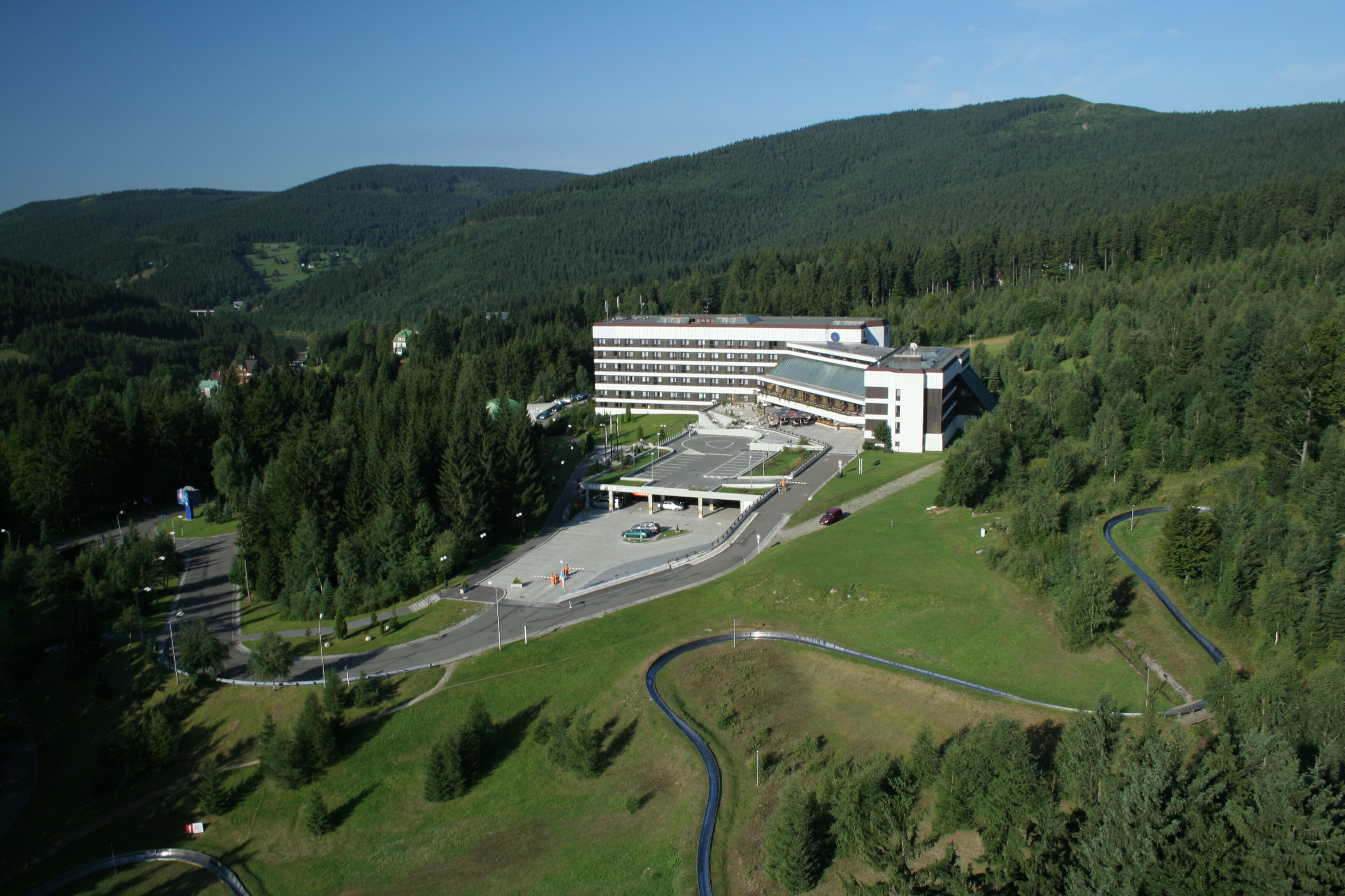 Vue aérienne d’un bâtiment moderne doté d’un parking et d’une route sinueuse.