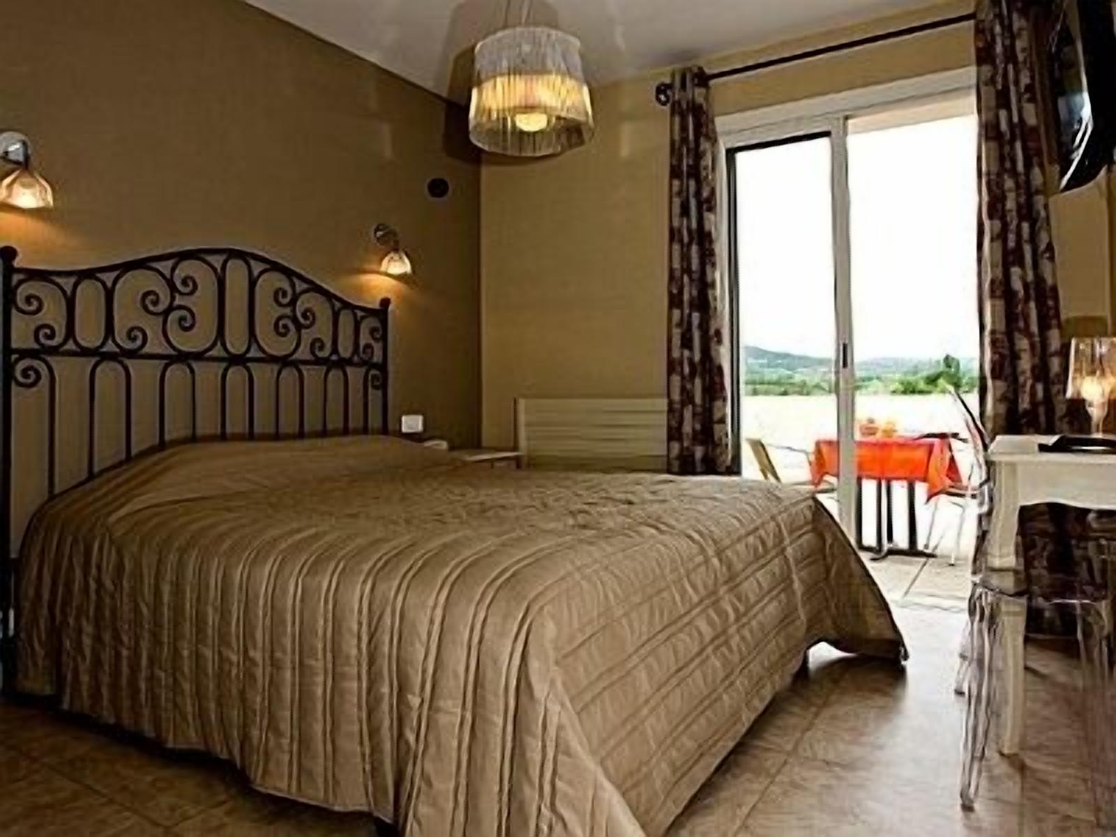 A bedroom with a bed, a desk, and a chair.