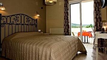 A bedroom with a bed, a desk, and a chair.
