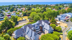 A residential area with a large house featuring multiple balconies, surrounded by lush greenery and a clear view of the sea. - Azureva Pornichet - Baie de La Baule (Pornichet)