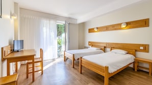 A room with two wooden beds, a desk, and a television. - Azureva Pornichet - Baie de La Baule (Pornichet)
