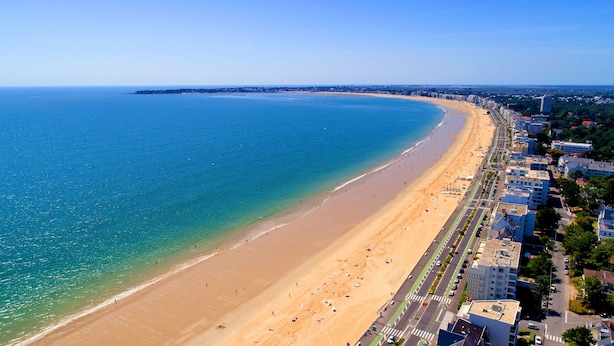A coastal cityscape with a wide sandy beach, a clear blue sea, and a row of modern buildings along the shore. - Azureva Pornichet - Baie de La Baule (Pornichet)