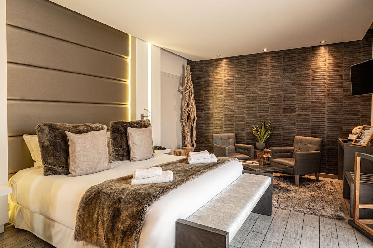 Un dormitorio moderno con una cama grande, un televisor de pantalla plana y una pared de piedra.