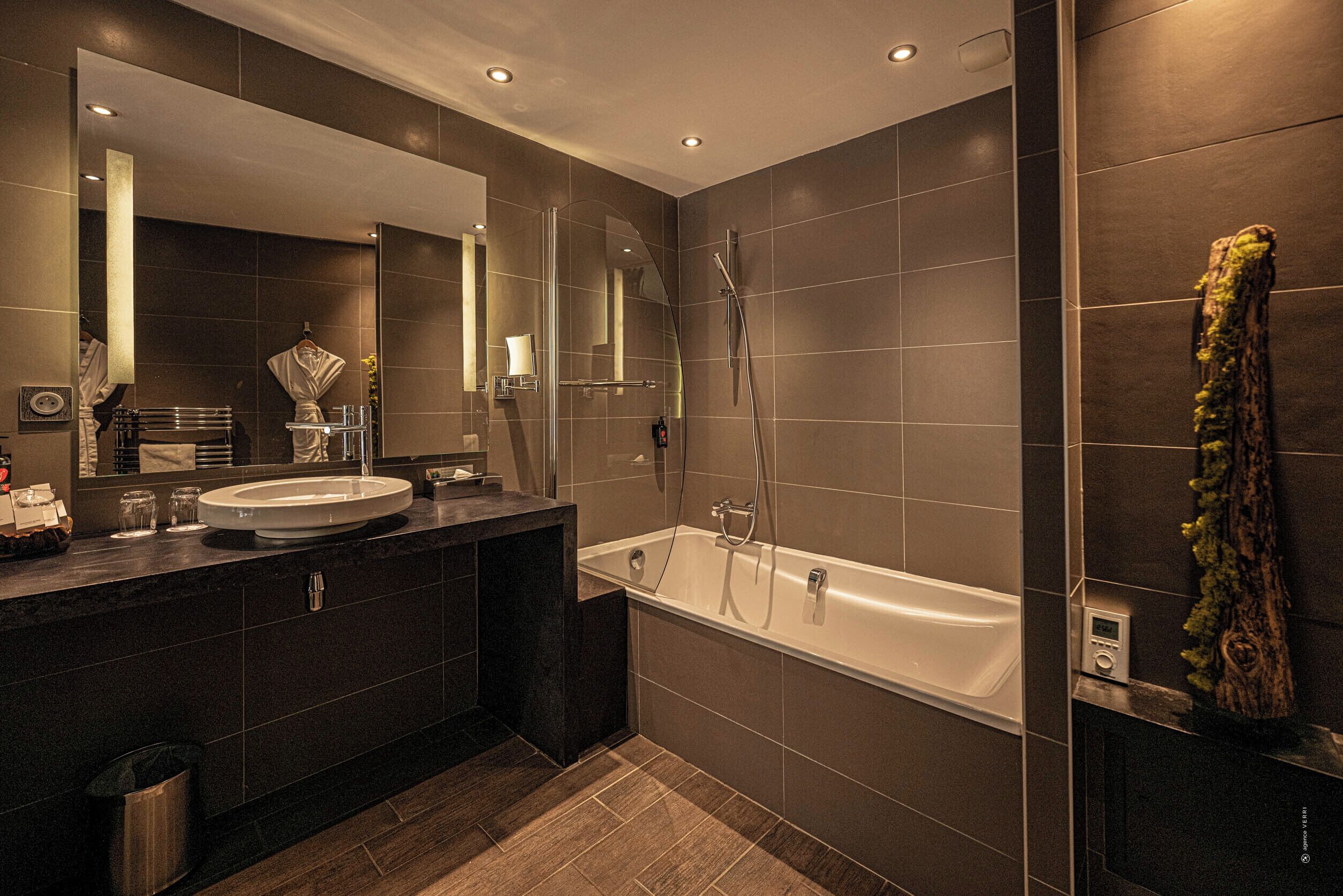 Une salle de bain moderne avec un meuble-lavabo à deux vasques, un grand miroir, une baignoire et une douche.