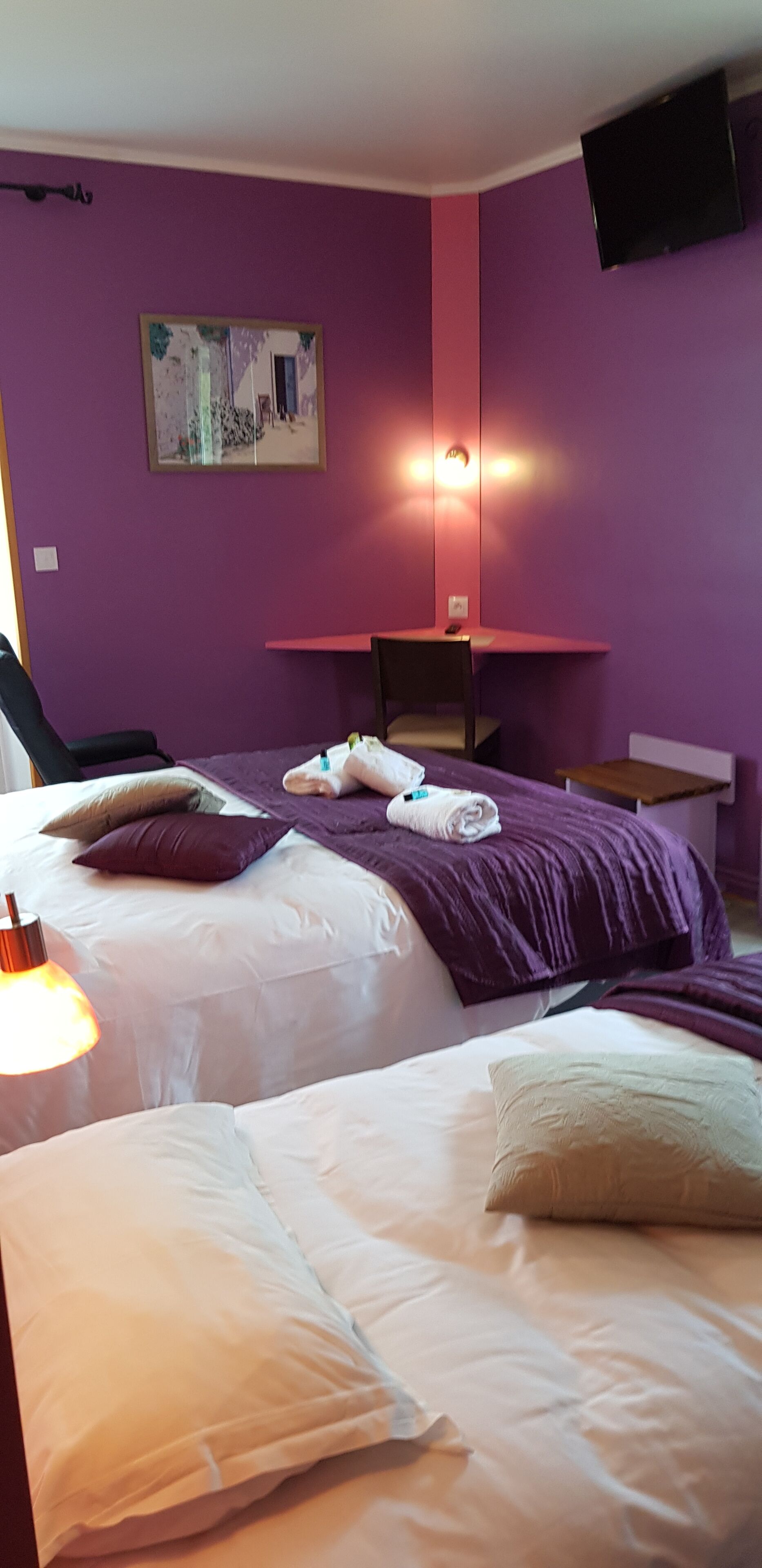 A room with two beds, a desk, and a chair.