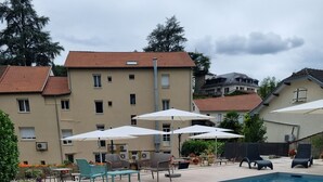 A swimming pool with a floating dolphin, lounge chairs, and umbrellas.