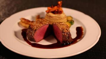 A plate with a steak, vegetables, and a small mound of food.