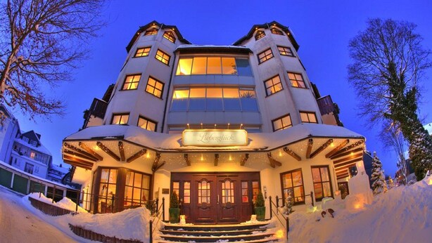 Un bâtiment recouvert de neige, avec une enseigne indiquant « Liebesglück » à l’entrée.