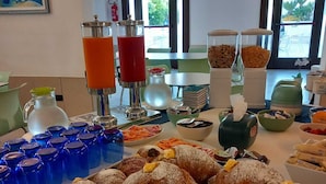 A buffet table with pastries, beverages, and condiments. - Hotel Villa Ionia (Avola)