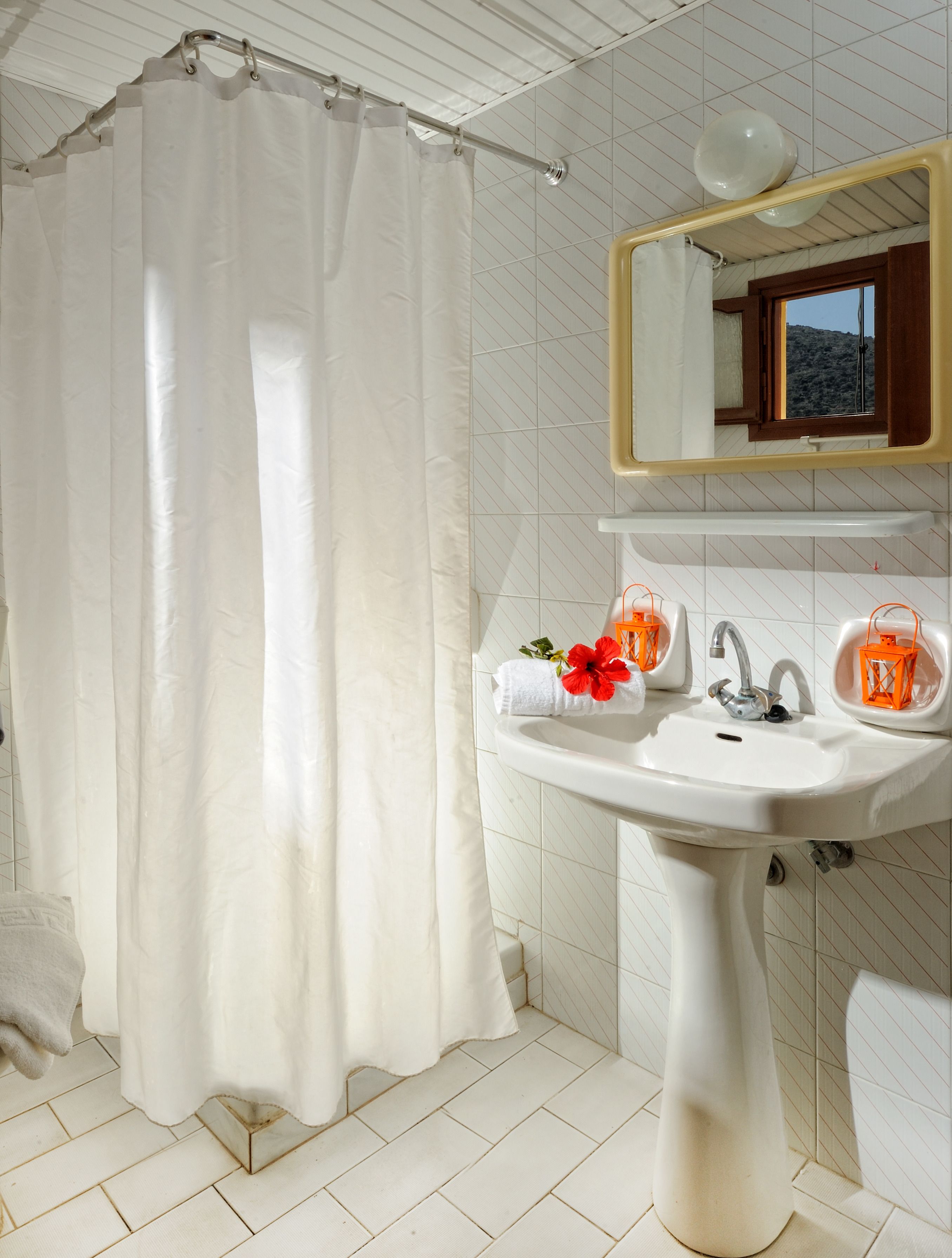 A bathroom with a white sink, a mirror, and a shower curtain.