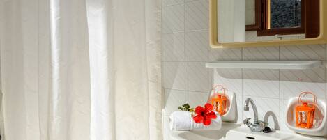 A bathroom with a white sink, a mirror, and a shower curtain.