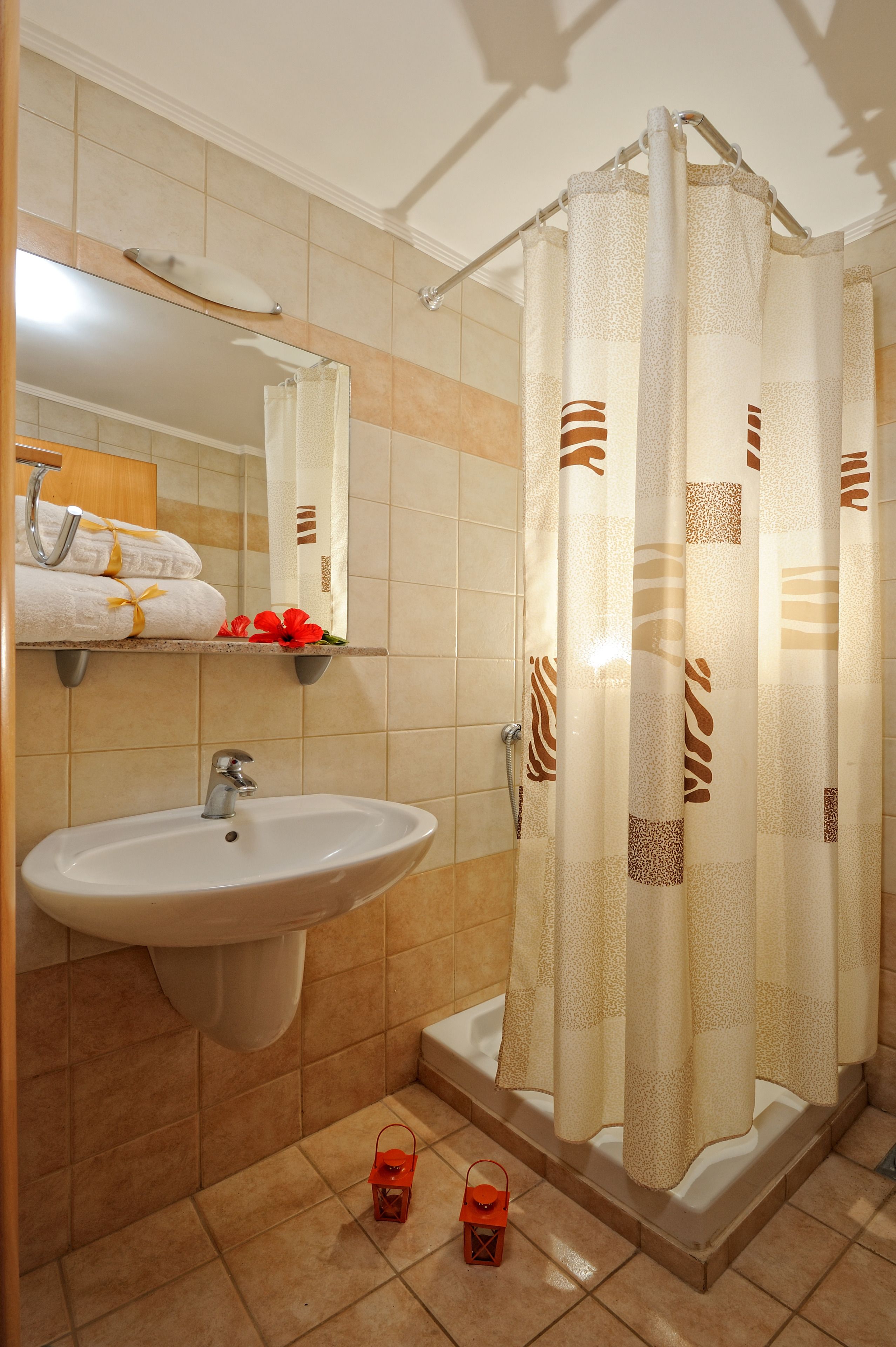 A bathroom with a sink, mirror, and shower curtain.