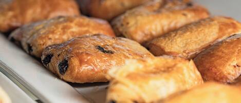 A tray of baked goods, likely pastries, in a bakery setting.