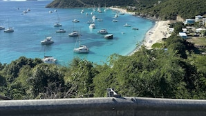 Blick auf die Küste mit Booten, einem Strand und einem Hügel.