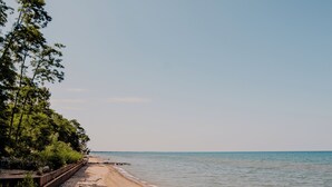 A beach with a wooden walkway and trees. - Hessenland Inn & Schatz Winery (Bluewater)