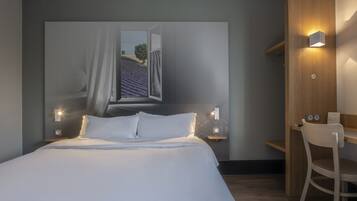 Une chambre à coucher avec un lit, des tables de chevet, un bureau et une chaise.