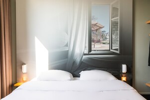 Une chambre d’hôtel avec un lit, des rideaux et une fenêtre donnant sur un espace extérieur.
