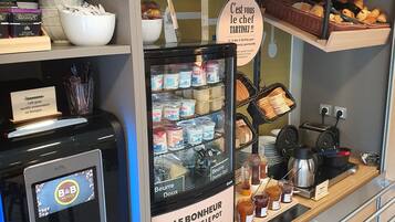 Eine Bäckertheke mit verschiedenen Backwaren und einer Kaffeemaschine.