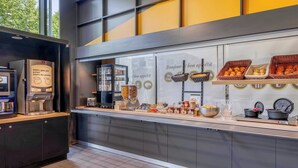 A breakfast buffet with various food items and a coffee machine. - B&B HOTEL Bordeaux Centre Bègles (Begles)
