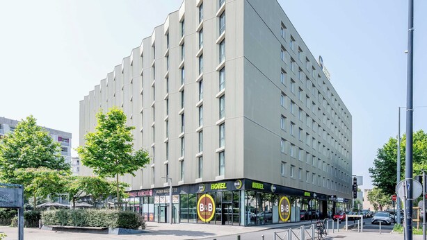 A modern hotel with a flat facade, multiple balconies, and a ground-level entrance with a glass facade. - B&B HOTEL Bordeaux Centre Bègles (Begles)