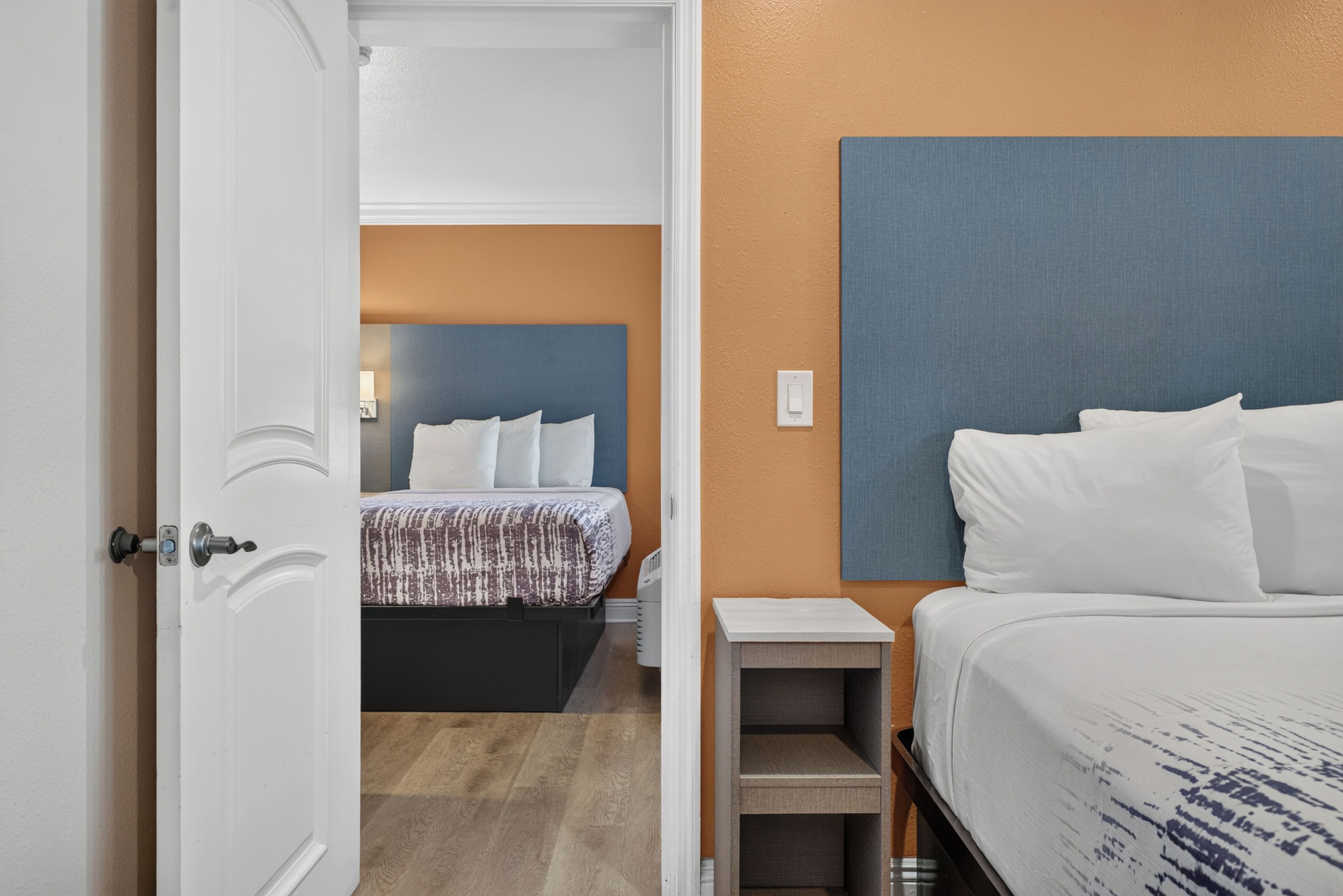 A hotel room with a bed, a bedside table, and a headboard.