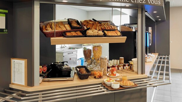 A bakery counter with various baked goods and breakfast items.