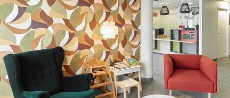 A reception area with a modern design, including a patterned wall, a reception desk, and seating arrangements.