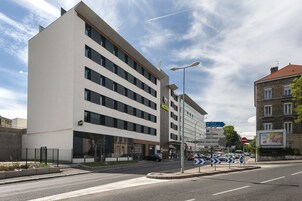Un hotel moderno con varios pisos, ventanas amplias y un llamativo letrero que dice 'HOTEL'.