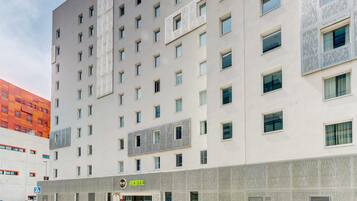 Un hotel moderno con fachada plana, varias ventanas y un llamativo letrero que dice 'HOTEL'.