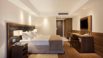 A modern hotel room with a large bed, bedside tables, a desk, and a mirror.