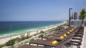 A hotel rooftop with sun loungers and a view of the beach and ocean. - Windsor Oceanico (Rio de Janeiro)