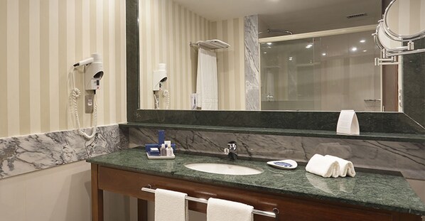 A bathroom with a marble countertop, a sink, a mirror, and a towel rack. - Windsor Oceanico (Rio de Janeiro)