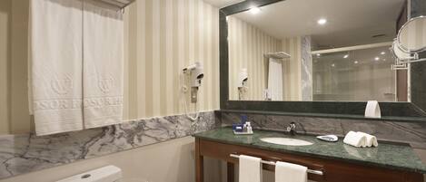 Une salle de bain avec un comptoir en marbre, un lavabo, un miroir et des toilettes.