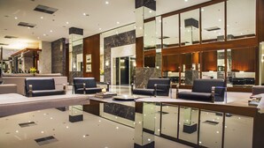 A modern lobby with seating areas, a reception desk, and a glass partition. - Windsor Oceanico (Rio de Janeiro)