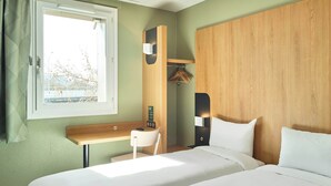 A hotel room with a bed, a desk, a chair, a wardrobe, and a window. - B&B HOTEL Paris Porte de la Villette (Aubervilliers)