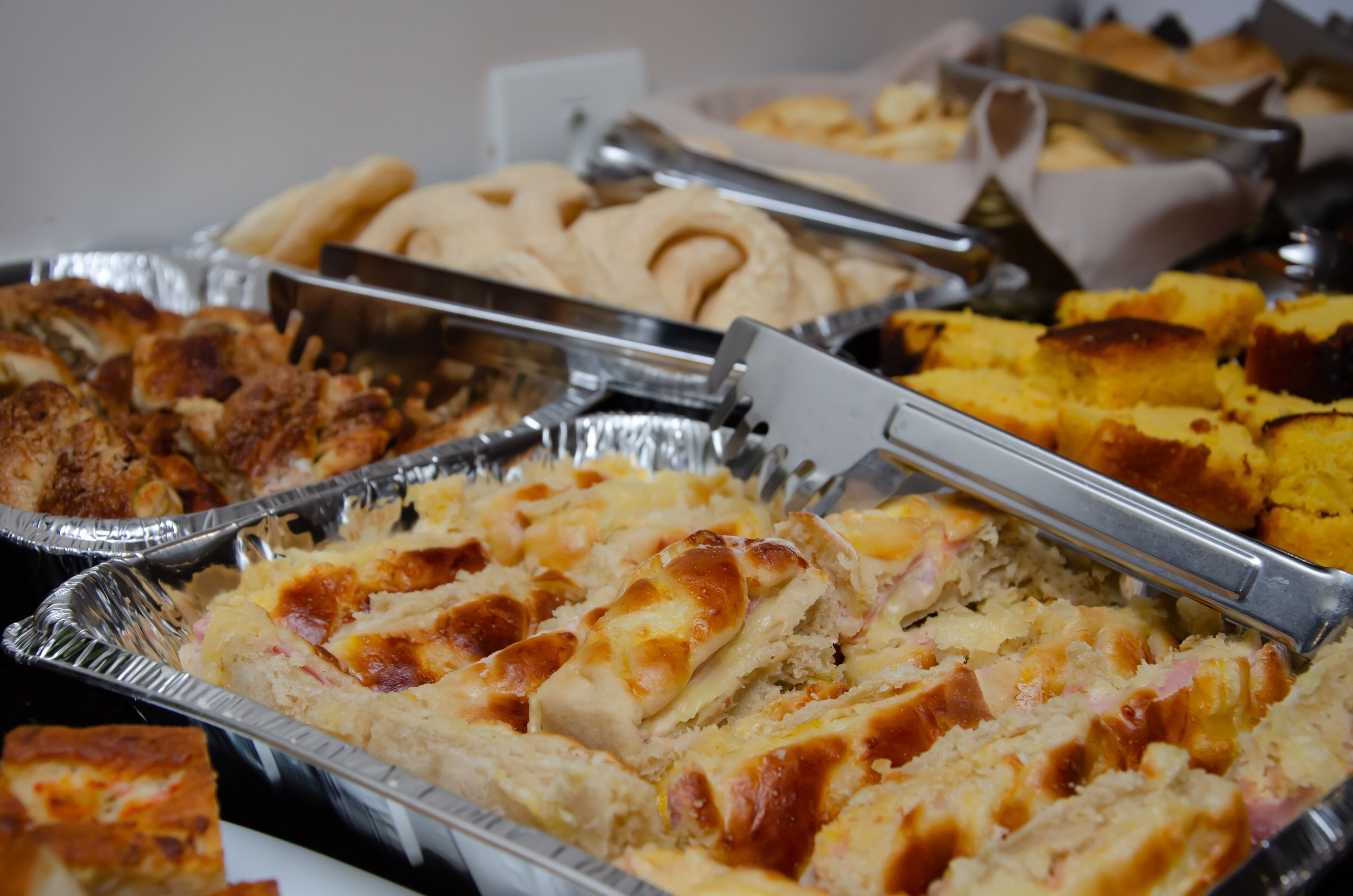 A buffet with various dishes including bread, casseroles, and baked items.