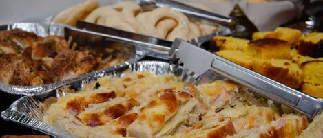 A buffet with various dishes including bread, casseroles, and baked items.