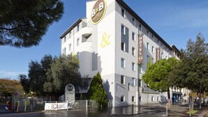 Un hotel tipo casa de huéspedes con diseño moderno, que muestra un logotipo destacado y un anuncio que indica una renovación.