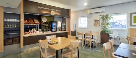 Una cafetería con interior de madera, una barra con diferentes productos alimenticios y un área de descanso con mesas y sillas.