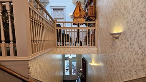 A staircase with a wooden handrail and a patterned wall.