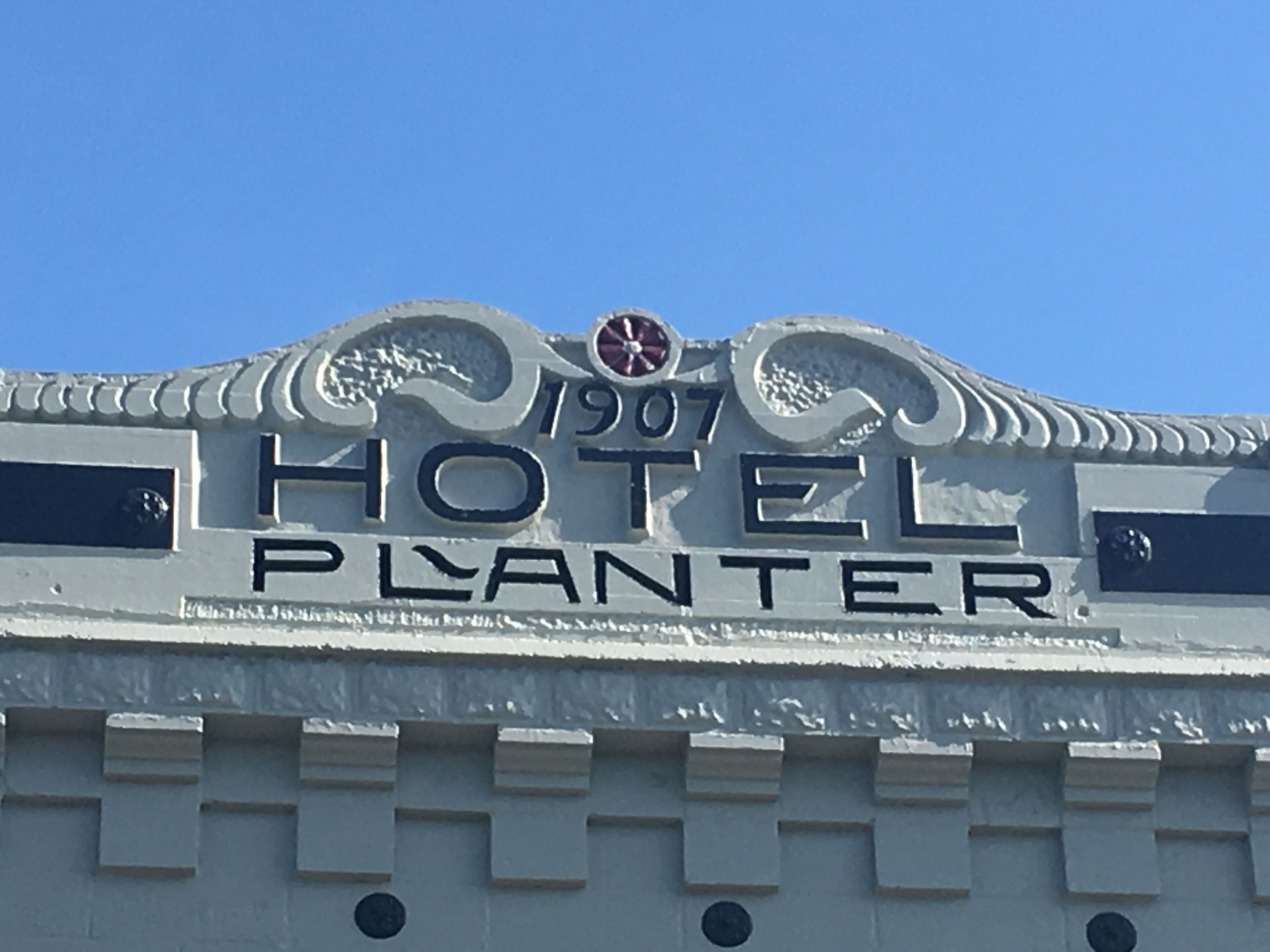 A hotel sign with the name "1907 Hotel Planter" and decorative elements.