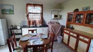 A compact kitchen with a refrigerator, microwave, and wooden cabinets. - Malfranza Apartments (Bridgetown)
