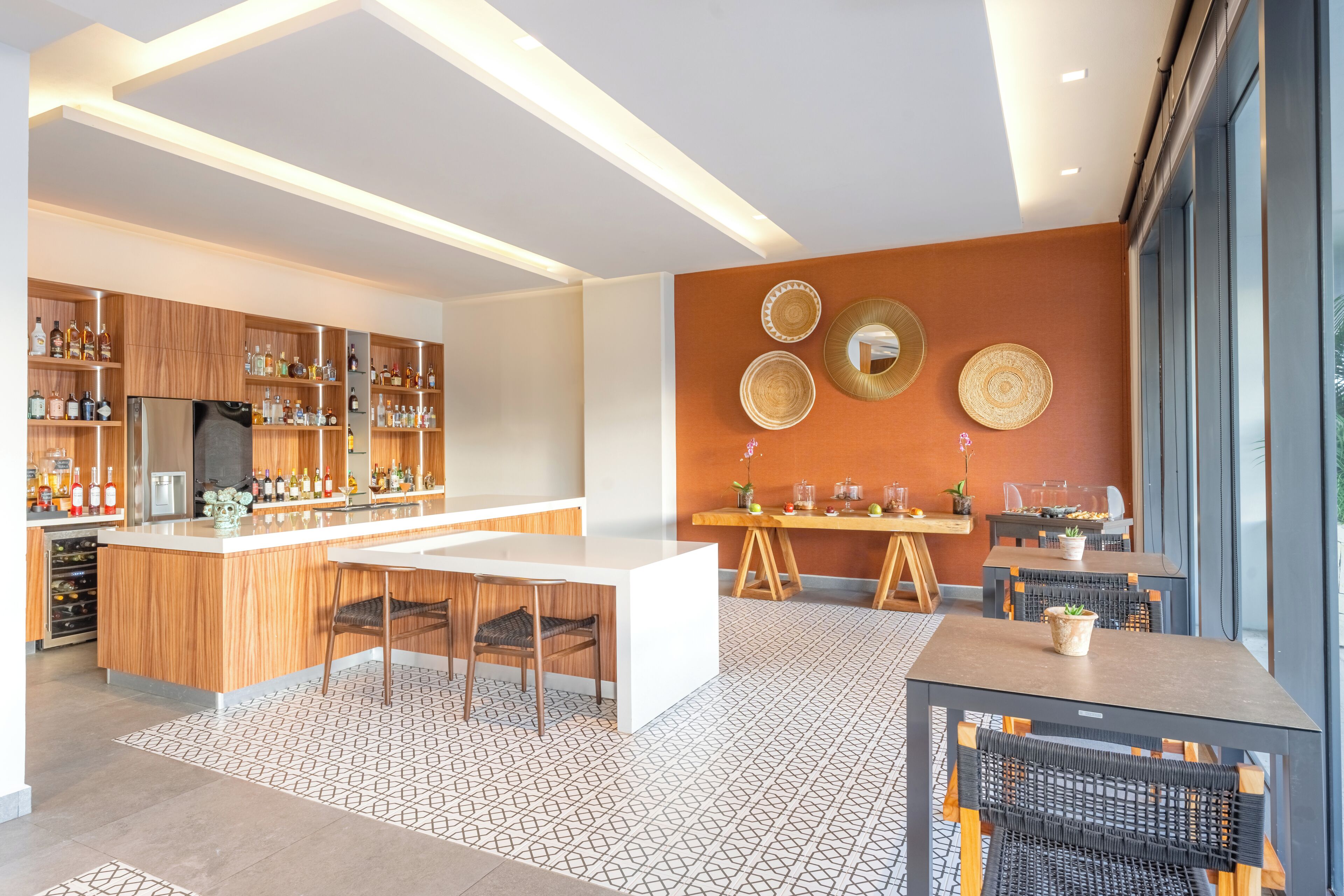 Une cuisine moderne avec des meubles en bois, un îlot central et un coin repas comprenant des tables et des chaises.