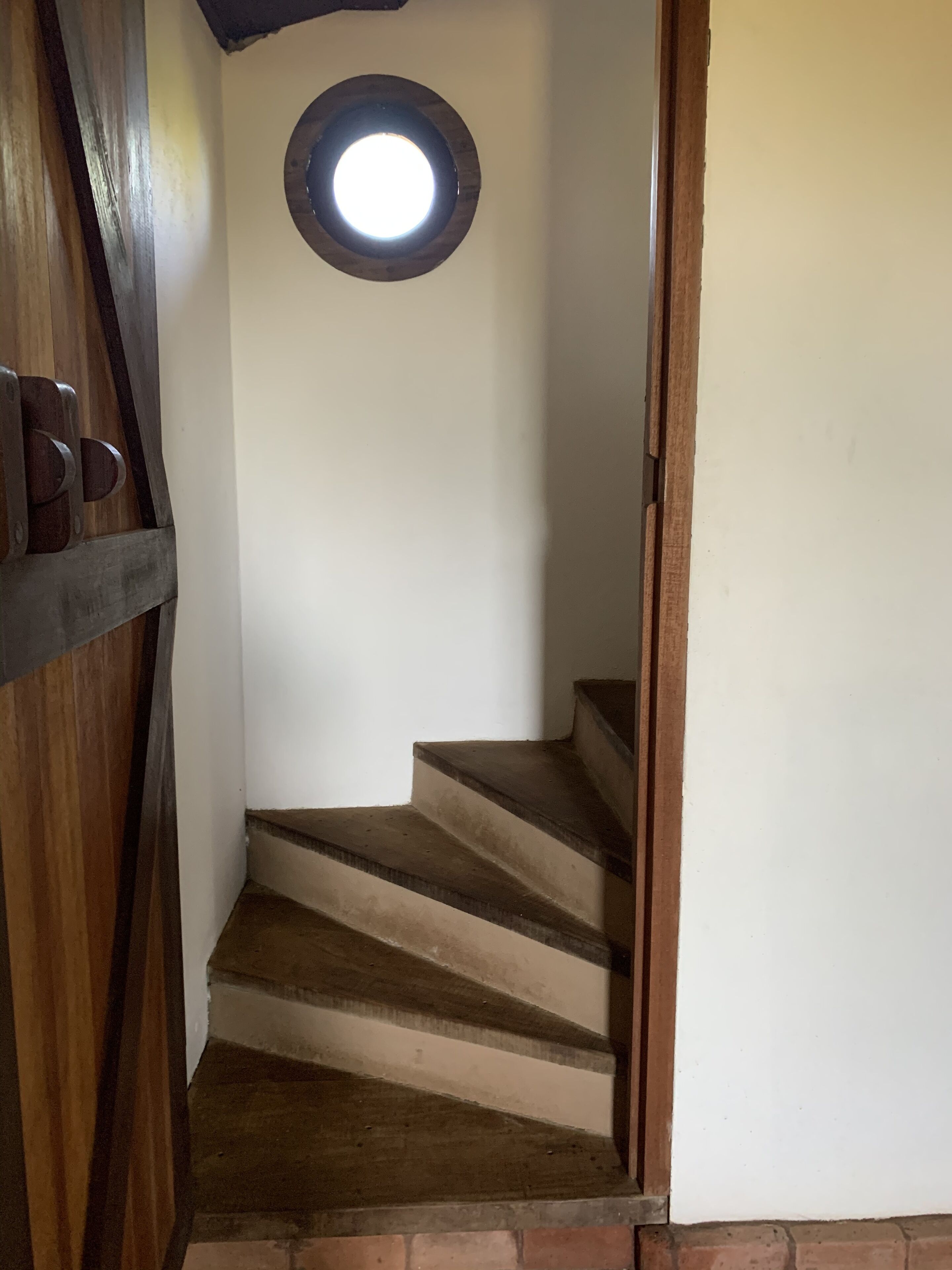 A staircase with wooden steps and a circular window at the top.