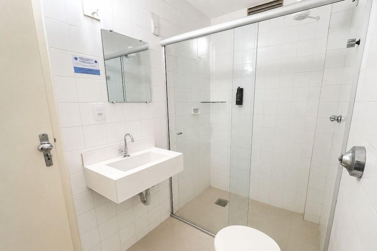 Een badkamer met een witte wastafel, spiegel en toilet.