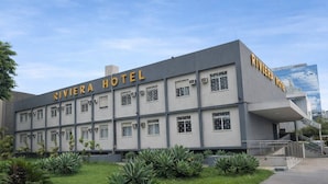 Een hotelgebouw met de naam 'RIVIERA HOTEL' op de gevel.
